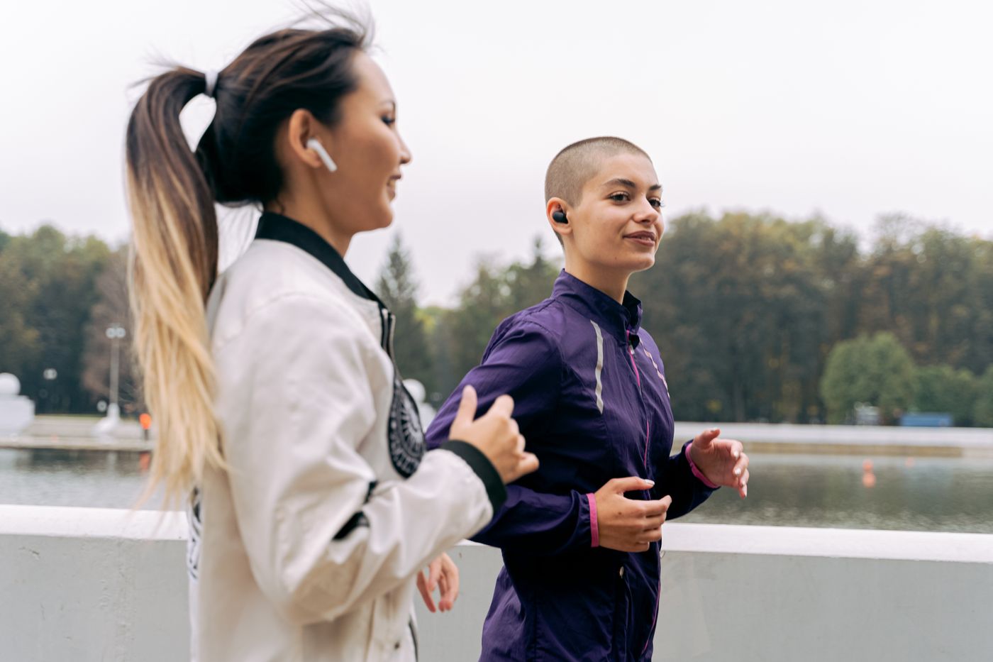 Placeholder: two women of different ethnicities jogging together outdoors and smiling